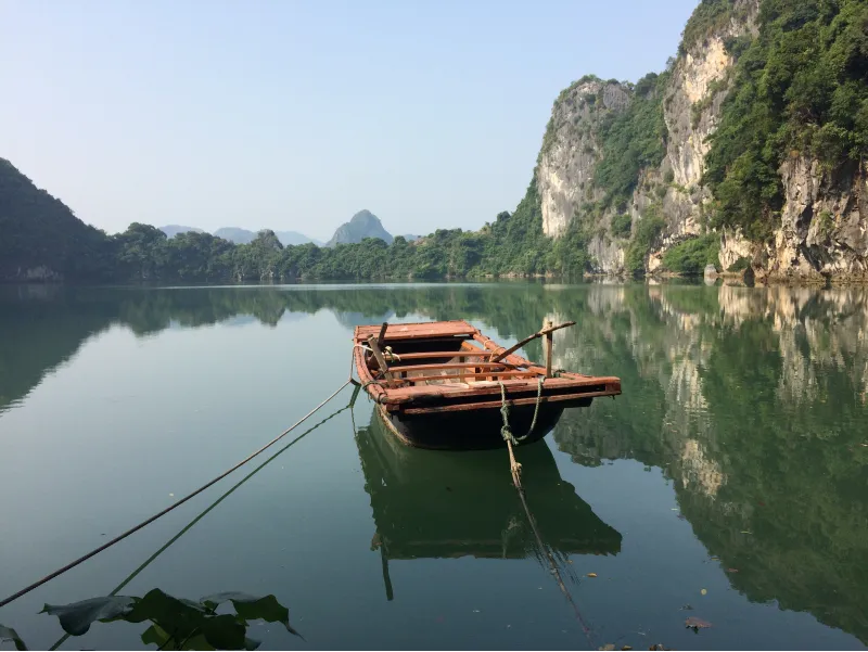 Barca tradicional de madera flotando en aguas tranquilas de la Bahía de Halong, Vietnam