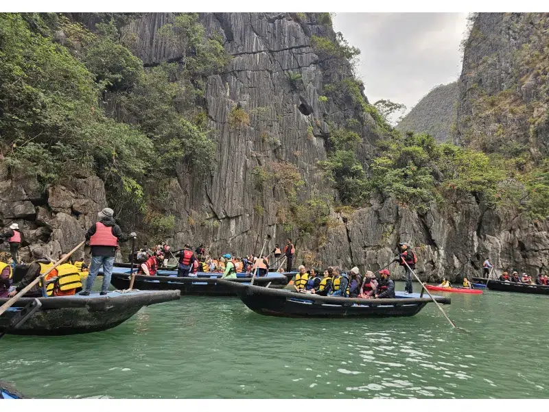 Kayak y barcas accediendo a cueva natural en la Bahía de Halong, Vietnam