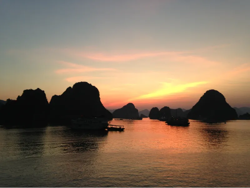 Atardecer en la Bahía de Halong con siluetas de islotes kársticos sobre el mar