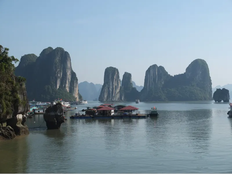 Panorámica de formaciones rocosas y casas flotantes en la Bahía de Halong