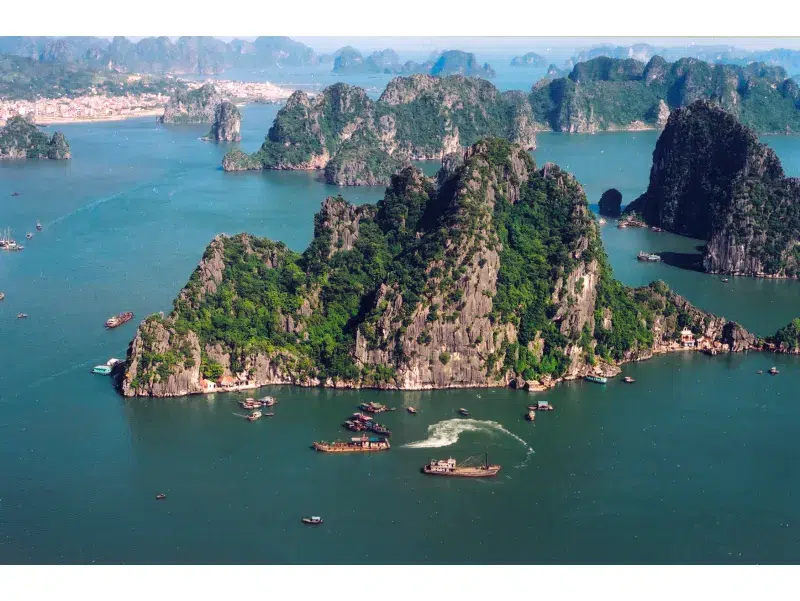 Vista panorámica aérea de la Bahía de Halong con formaciones kársticas y barcos