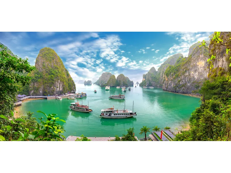 Bahía de Halong con aguas esmeralda y cruceros en un día soleado