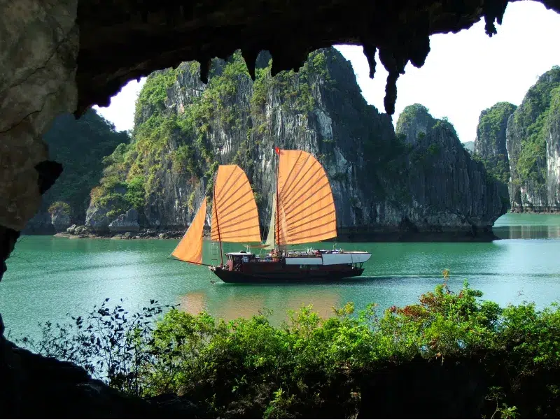 Velero tradicional visto desde una cueva natural en la Bahía de Halong, Vietnam