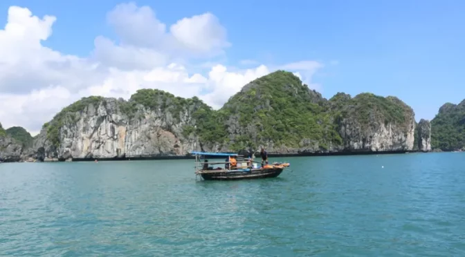 Barca de pescadores navegando en la Bahía de Lan Ha con fondo montañoso