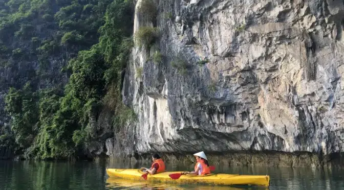 Turistas en kayak explorando los acantilados de la bahía de Lan Ha, una experiencia activa en el corazón de Vietnam