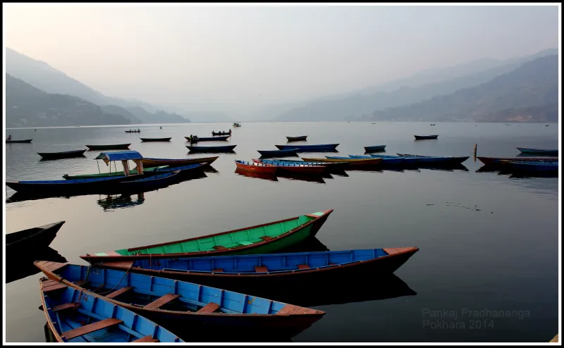 Barcas de colores en el lago Phewa de Pokhara al amanecer durante un viaje a medida a Nepal.