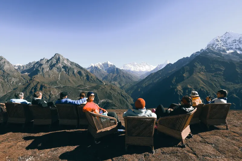 Viajeros descansando con vistas al Himalaya en Kongde, experiencia única en Nepal.