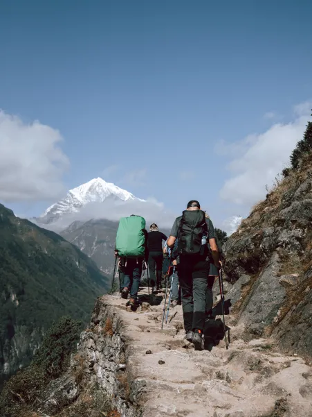 Trekking por sendero de montaña con vistas al Himalaya en un viaje cultural a Nepal.