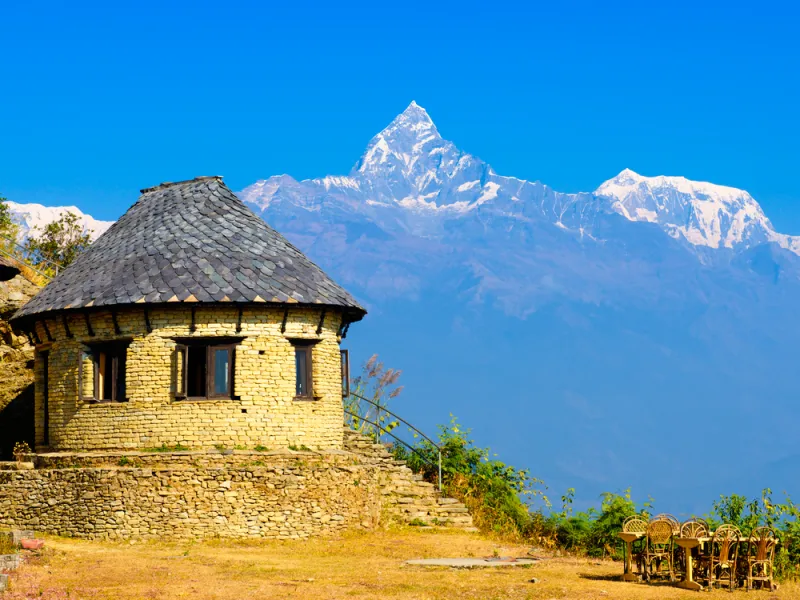 Lodge de piedra en Landruk con vistas al pico Machapuchare en el Himalaya, Nepal.