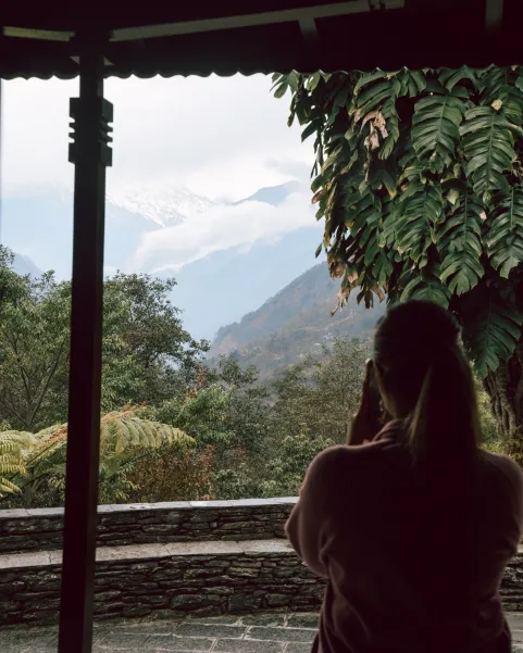 Viajera contemplando las montañas nevadas del Himalaya desde lodge en Nepal.