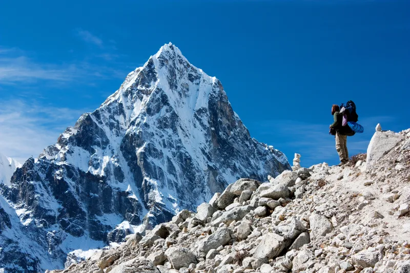 Montañista frente a la cima nevada del Himalaya en trekking hacia el Everest.