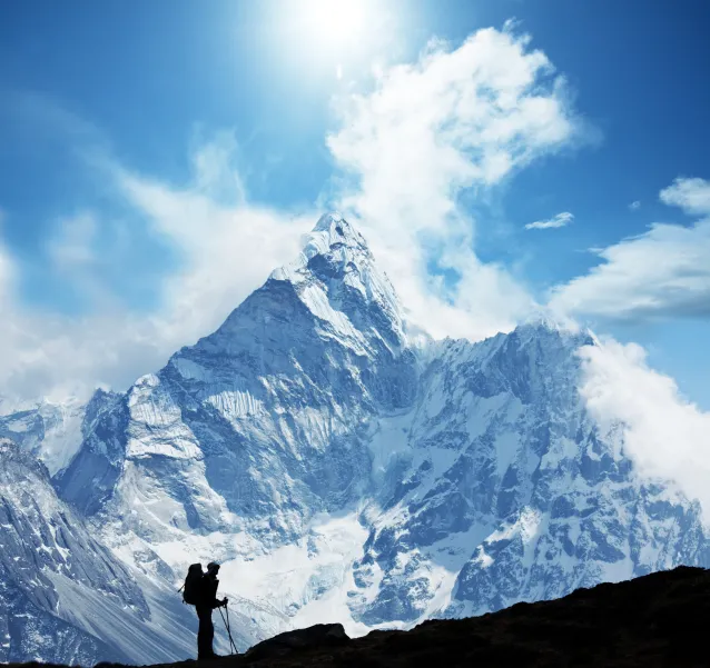 Senderista en silueta frente al pico Ama Dablam en los Himalayas de Nepal.