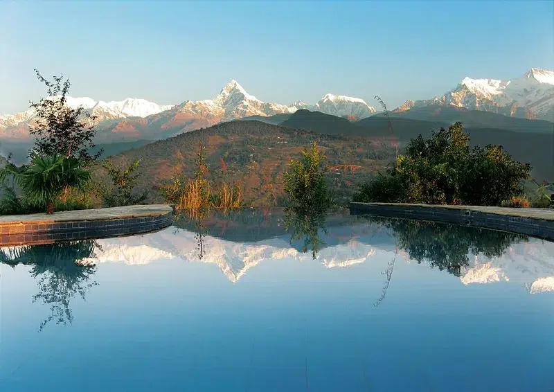 Piscina infinita con reflejo de los picos del Annapurna en Nepal.