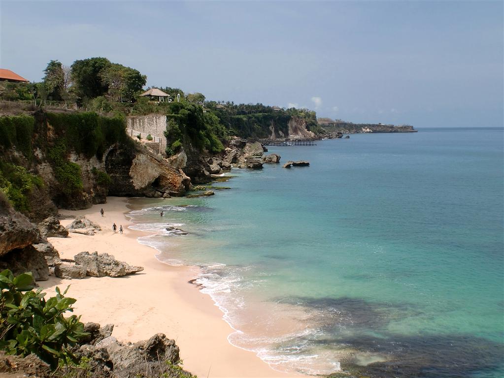 Viaje a Indonesia — cala con acantilados de roca, arena clara y mar cristalino