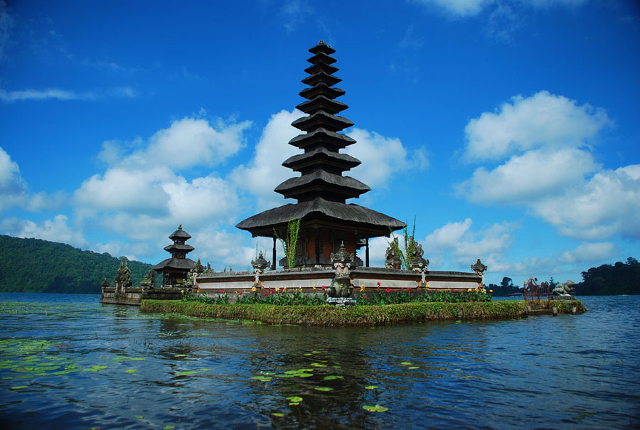 templo flotante en un lago con tejados escalonados y paisaje montañoso de viaje en indonesia