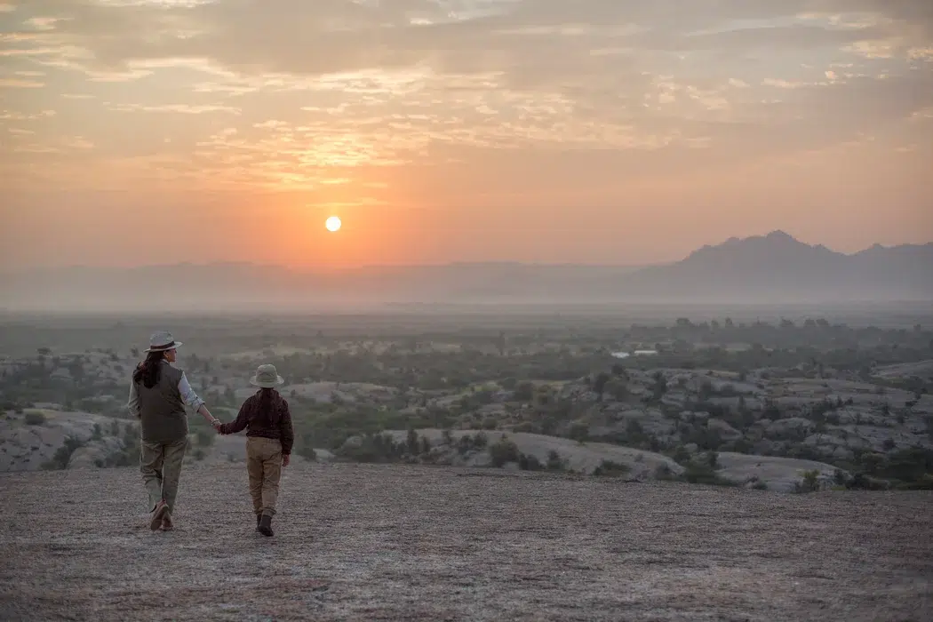 Viajeros contemplando el atardecer en un paisaje natural de India
