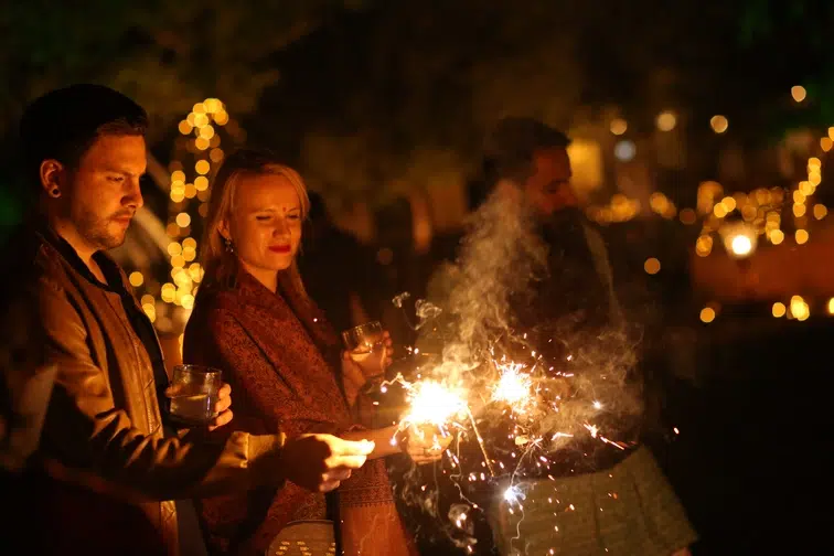 Viajeros celebrando Diwali con bengalas durante un viaje a medida por India