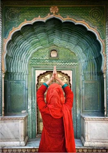 Mujer meditando ante una puerta tradicional durante un viaje espiritual por India
