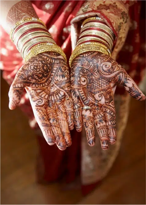 Manos decoradas con mehndi y pulseras tradicionales en una ceremonia de India